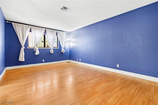 empty room featuring hardwood / wood-style floors and a textured ceiling