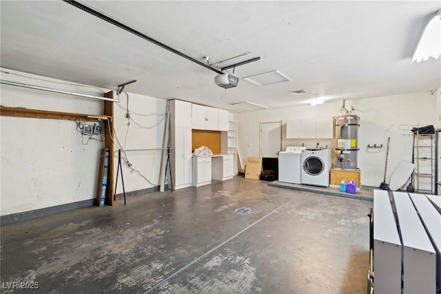 garage with a garage door opener, washing machine and clothes dryer, and strapped water heater