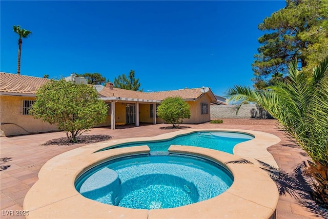 view of pool with an in ground hot tub and a patio