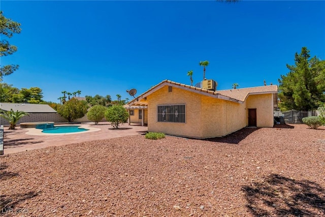 rear view of property featuring central AC, a fenced in pool, and a patio area