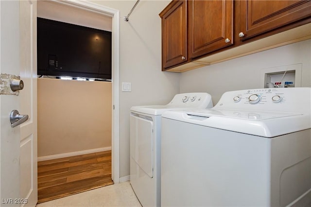 clothes washing area with light tile patterned floors, baseboards, cabinet space, and independent washer and dryer