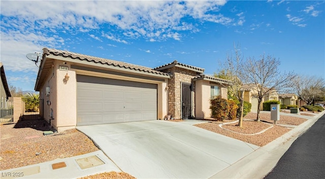 mediterranean / spanish house with concrete driveway, stone siding, a tiled roof, an attached garage, and stucco siding