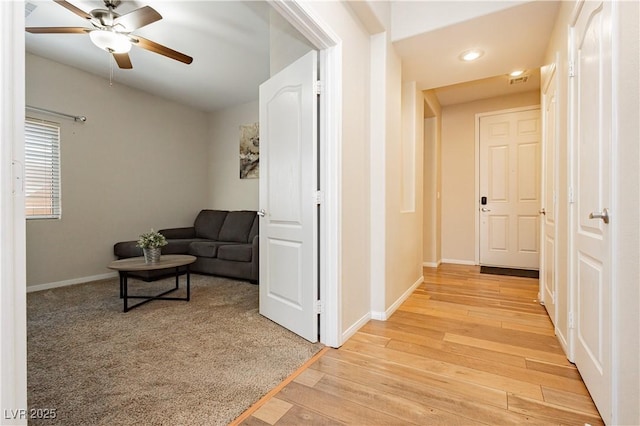 hallway with light wood-style flooring, baseboards, and recessed lighting