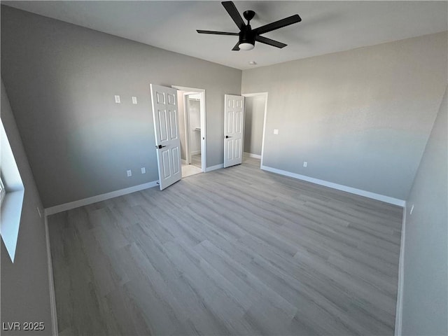 unfurnished bedroom with light wood finished floors, ceiling fan, and baseboards