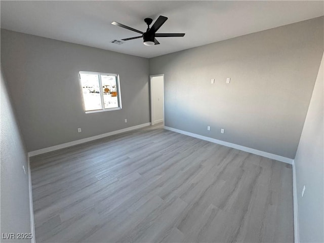 empty room with a ceiling fan, light wood-style floors, visible vents, and baseboards