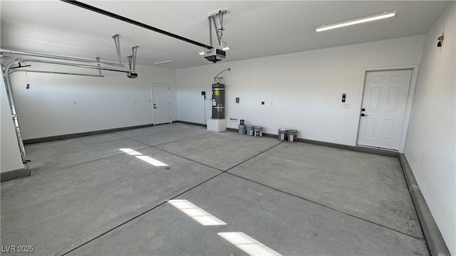 garage featuring baseboards, secured water heater, and a garage door opener