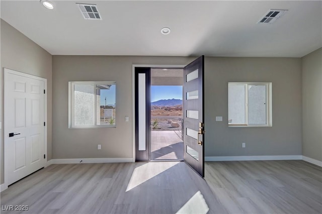 entryway featuring light wood finished floors, baseboards, visible vents, and recessed lighting