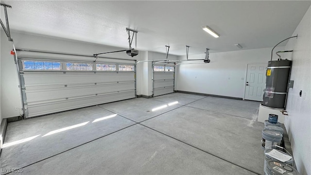 garage featuring a garage door opener, strapped water heater, and baseboards