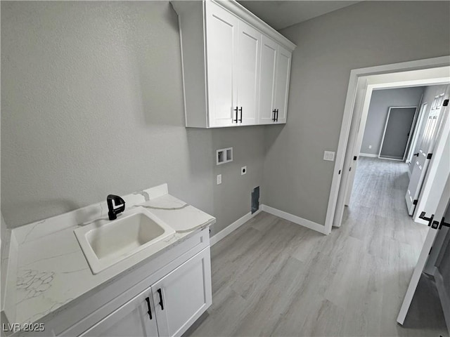 laundry area with cabinet space, light wood-style flooring, electric dryer hookup, washer hookup, and a sink