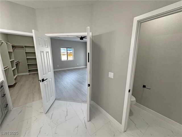 bathroom with vanity, a ceiling fan, baseboards, marble finish floor, and a spacious closet