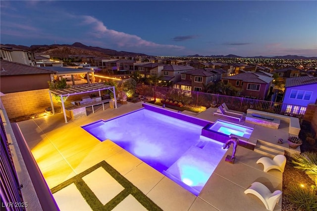 pool at dusk featuring an in ground hot tub, a pergola, a mountain view, and a patio area