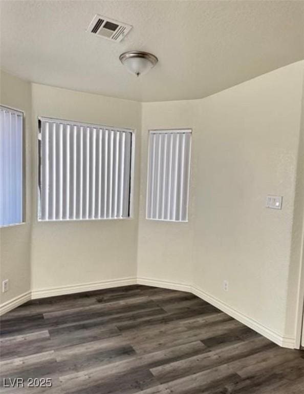 empty room featuring dark wood-type flooring and a textured ceiling