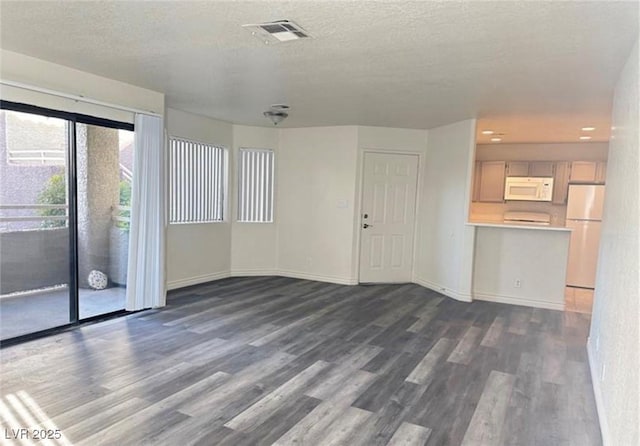 unfurnished living room with dark hardwood / wood-style floors and a textured ceiling