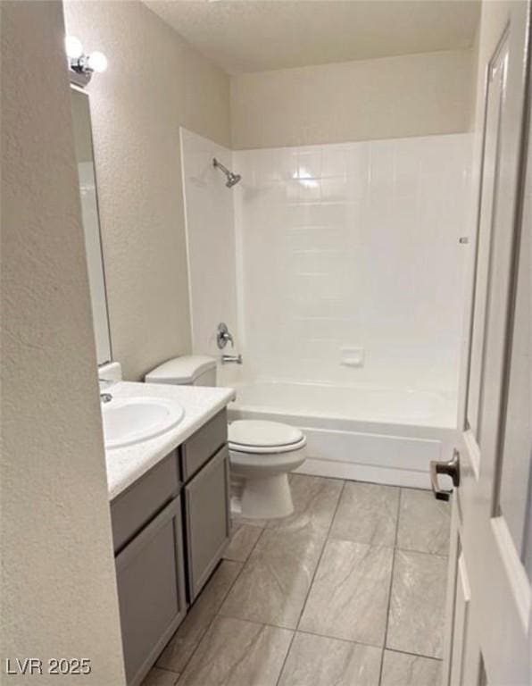 full bathroom with vanity, a textured ceiling, bathtub / shower combination, and toilet