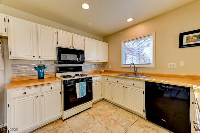 kitchen featuring sink, light tile patterned floors, tasteful backsplash, black appliances, and white cabinets