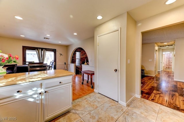 kitchen with wooden counters, white cabinets, and light wood-type flooring