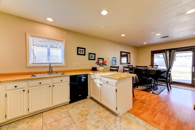 kitchen featuring dishwasher, sink, kitchen peninsula, and white cabinets