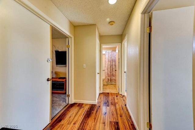 corridor featuring hardwood / wood-style floors and a textured ceiling