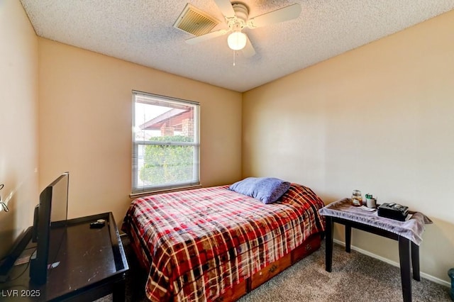 bedroom with ceiling fan, carpet floors, and a textured ceiling