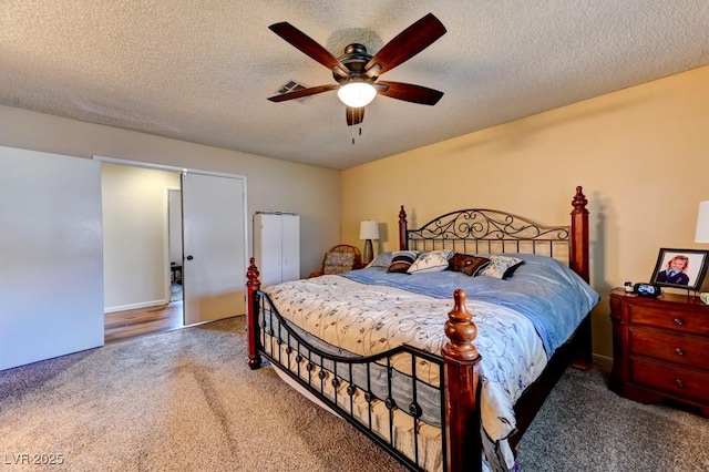 bedroom with ceiling fan, carpet, and a textured ceiling