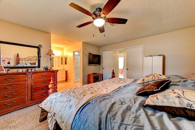 bedroom with ceiling fan, light carpet, and a textured ceiling