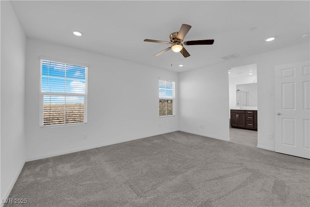 empty room featuring ceiling fan and light carpet