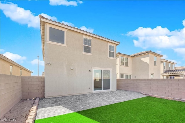 back of property featuring a yard and a patio area