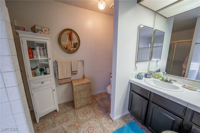 bathroom featuring vanity, toilet, and a shower with door