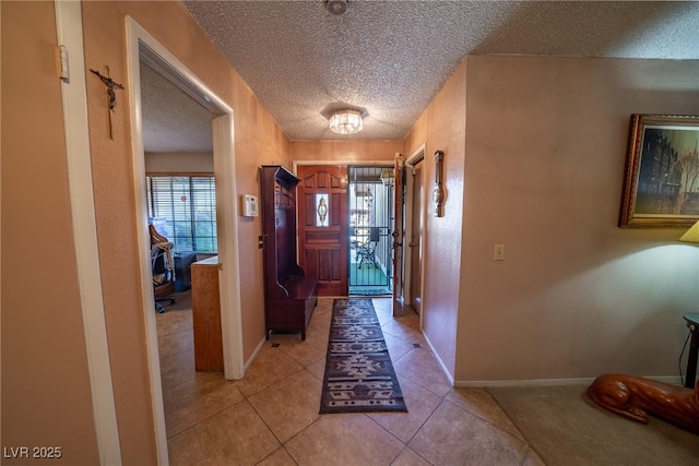 foyer entrance featuring light tile patterned floors and a textured ceiling