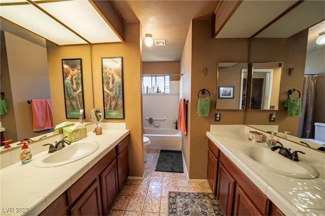 full bathroom with vanity, shower / bath combo, a textured ceiling, and toilet