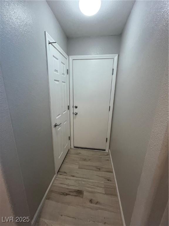 doorway to outside featuring light wood-style flooring and baseboards