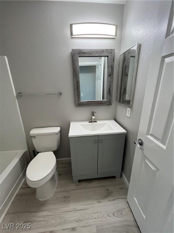 full bathroom with vanity, toilet, and baseboards