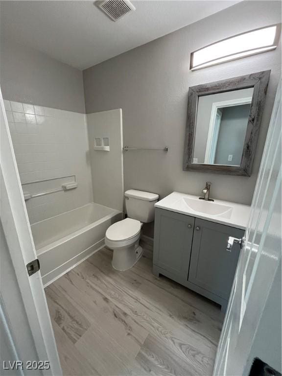 full bathroom featuring vanity, wood-type flooring, bathing tub / shower combination, and toilet