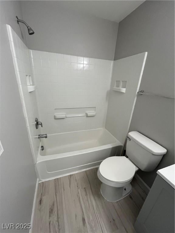 bathroom with vanity, bathtub / shower combination, wood finished floors, and toilet