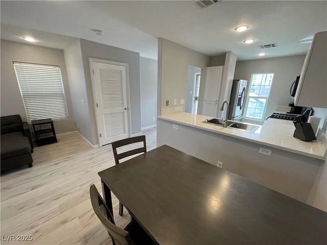 dining area with sink and light wood-type flooring