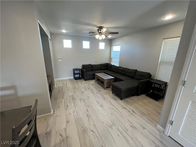 living room featuring ceiling fan and light hardwood / wood-style floors