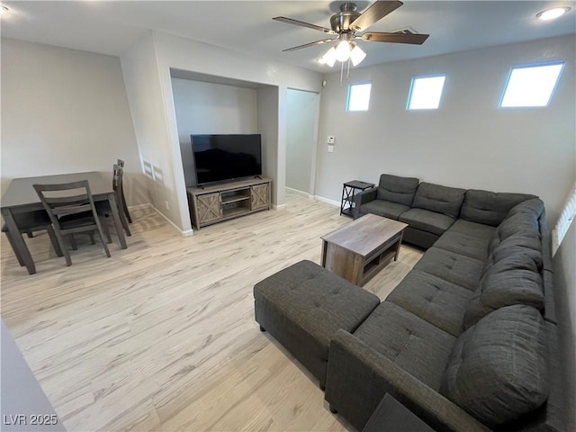 living room featuring ceiling fan and light hardwood / wood-style flooring