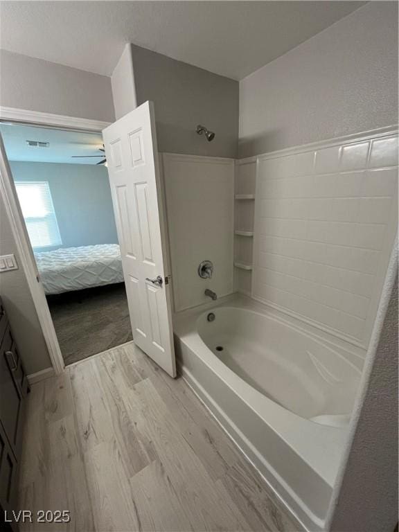 bathroom with ceiling fan, tub / shower combination, and hardwood / wood-style floors