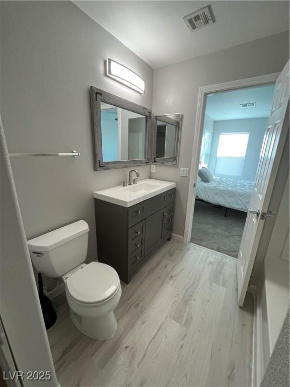 bathroom featuring wood-type flooring, vanity, and toilet