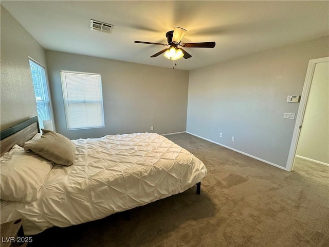 carpeted bedroom featuring visible vents, ceiling fan, and baseboards