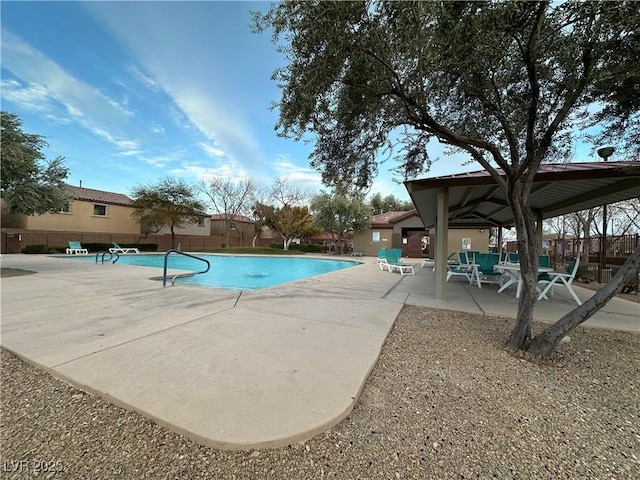 pool with a patio area and fence