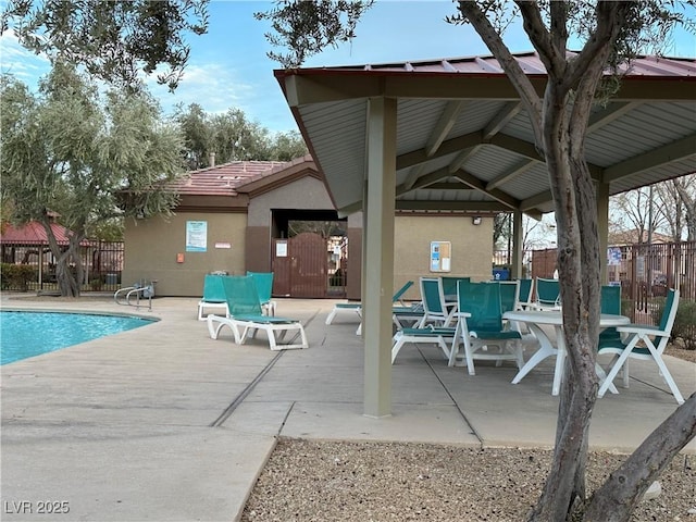 community pool with a patio area and fence