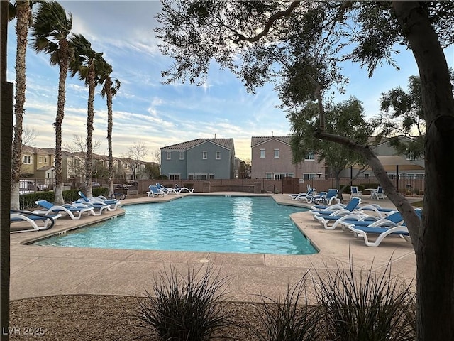 pool featuring a patio area, fence, and a residential view