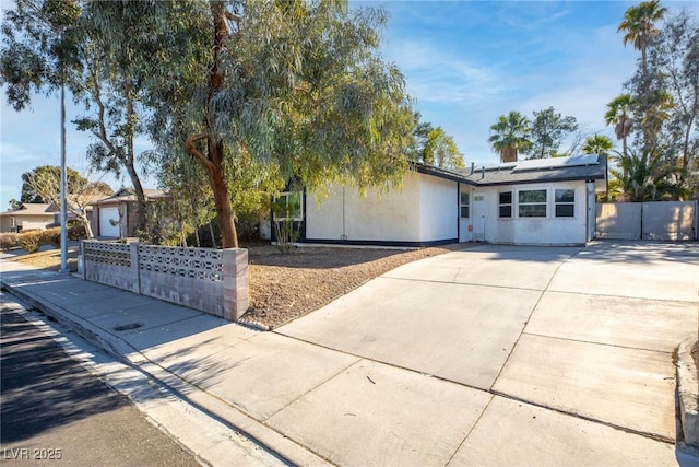 ranch-style home featuring a garage and solar panels