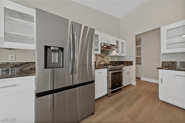 kitchen featuring light hardwood / wood-style flooring, white cabinetry, backsplash, dark stone countertops, and stainless steel appliances