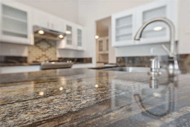 details featuring sink, white cabinets, and range