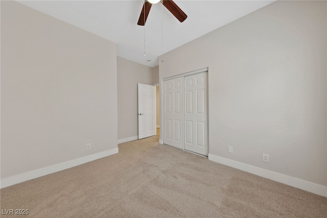 unfurnished bedroom featuring ceiling fan, light colored carpet, and a closet