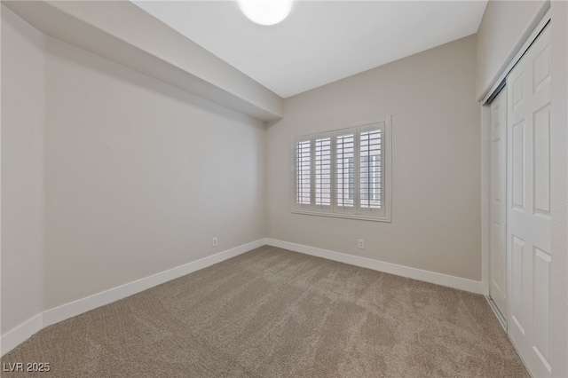 unfurnished bedroom with light colored carpet and a closet