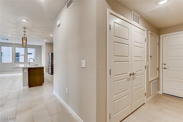 hallway with sink and light tile patterned floors