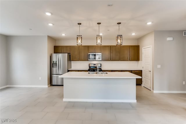 kitchen featuring stainless steel appliances, tasteful backsplash, a kitchen island with sink, and pendant lighting